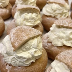 En klassisk semla med vit fluffig grädde. Vitt florsocker är pudrat öve det trekantiga locket.