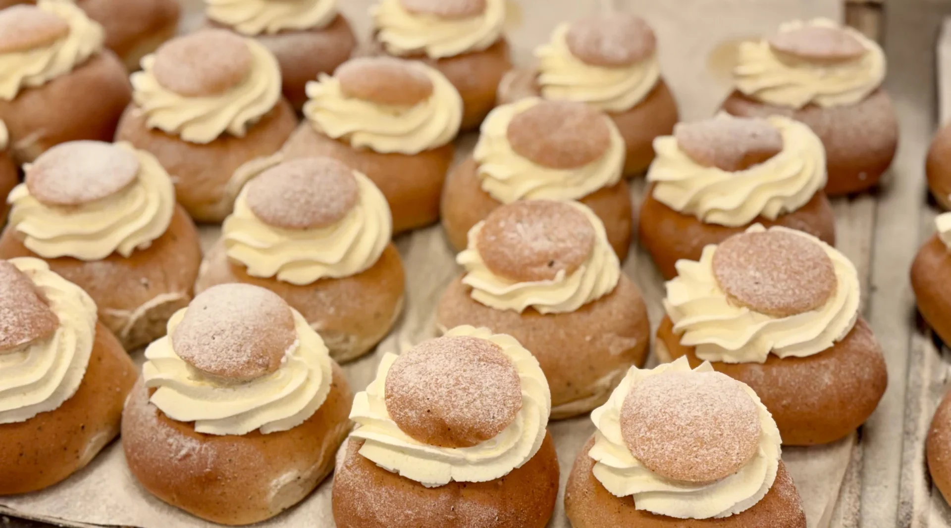 Flera semlor med grädde och mandelmassa på en plåt