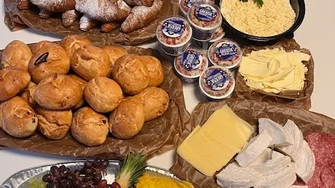 Frukostbuffé med frallor, yoghurt, äggröra och ost.