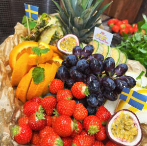 Fruktfat med Ananas, apelsin, meloner, vindruvor och jordgubbar. Dekorerar med sverige flaggor.