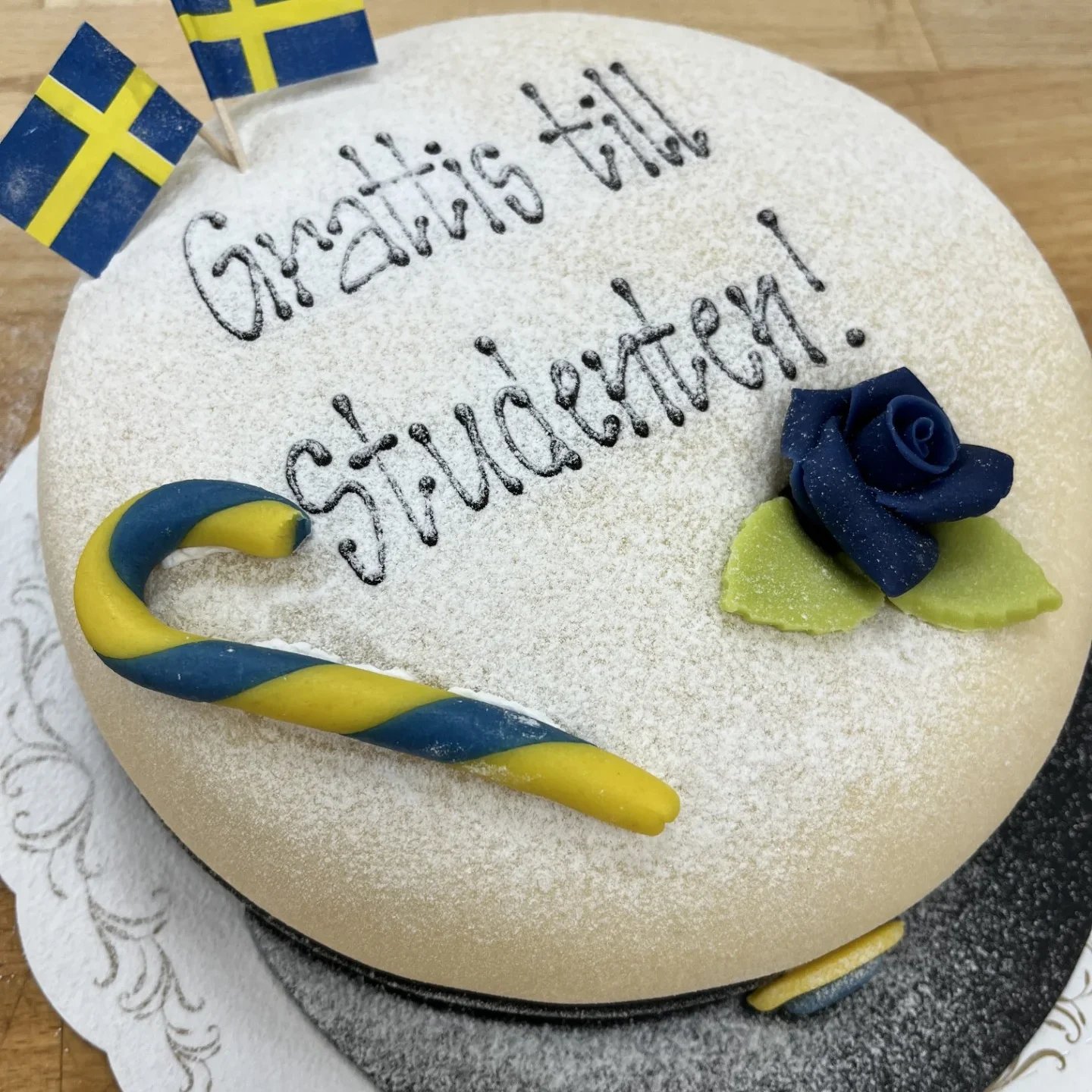 Studentmössa med text, ros och flaggor