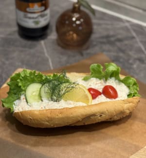Baguette fylld med krämig skagenröra toppad med grönsaker och färsk dill
