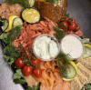 En lax och skaldjursbricka som bjuder på färska räkor, kallrökt lax, gravad lax, pepparlax, skaldjurspaté, romsås, limeaioli, hovmästarsås och toppad med grönsaker.
