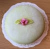 Grön operatårta dekoreras med en rosa ros