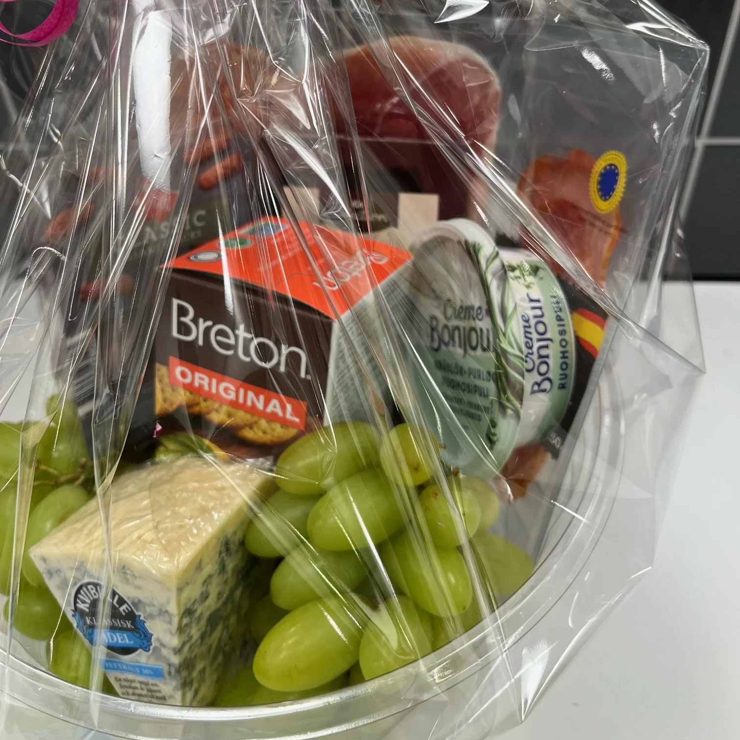 En korg med olika delikatesser, frukt och gott.