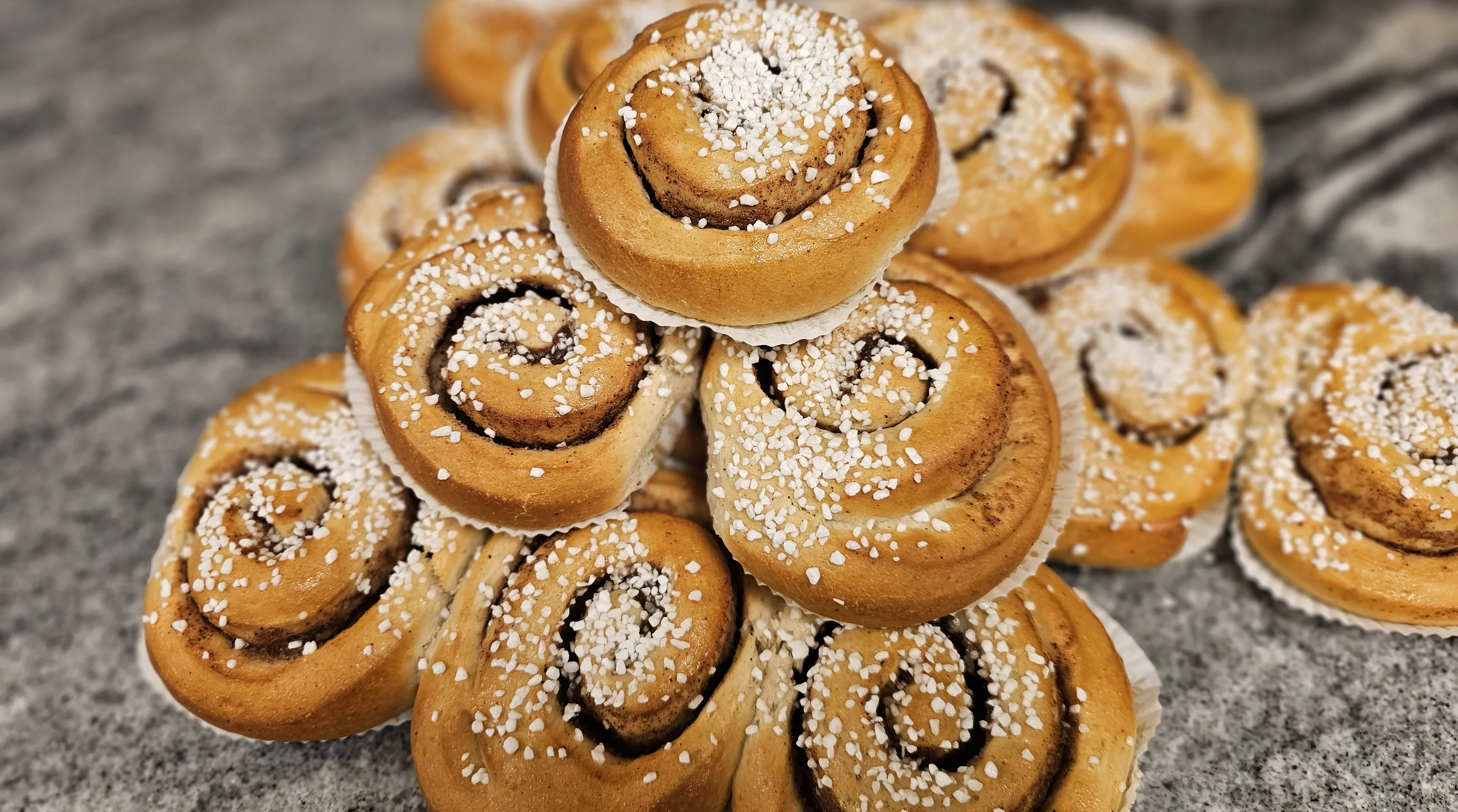 Kanelbullar med pärlsocker på en bänk