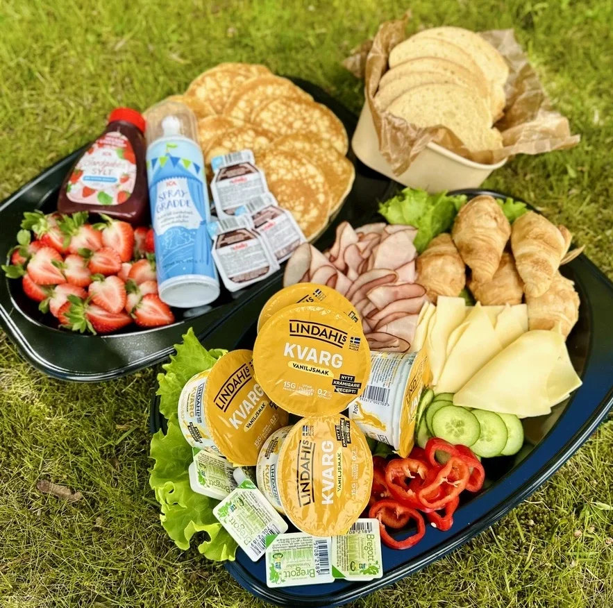 Studentfrukostfat med pannkakor, sylt, bröd, skinka och smör.