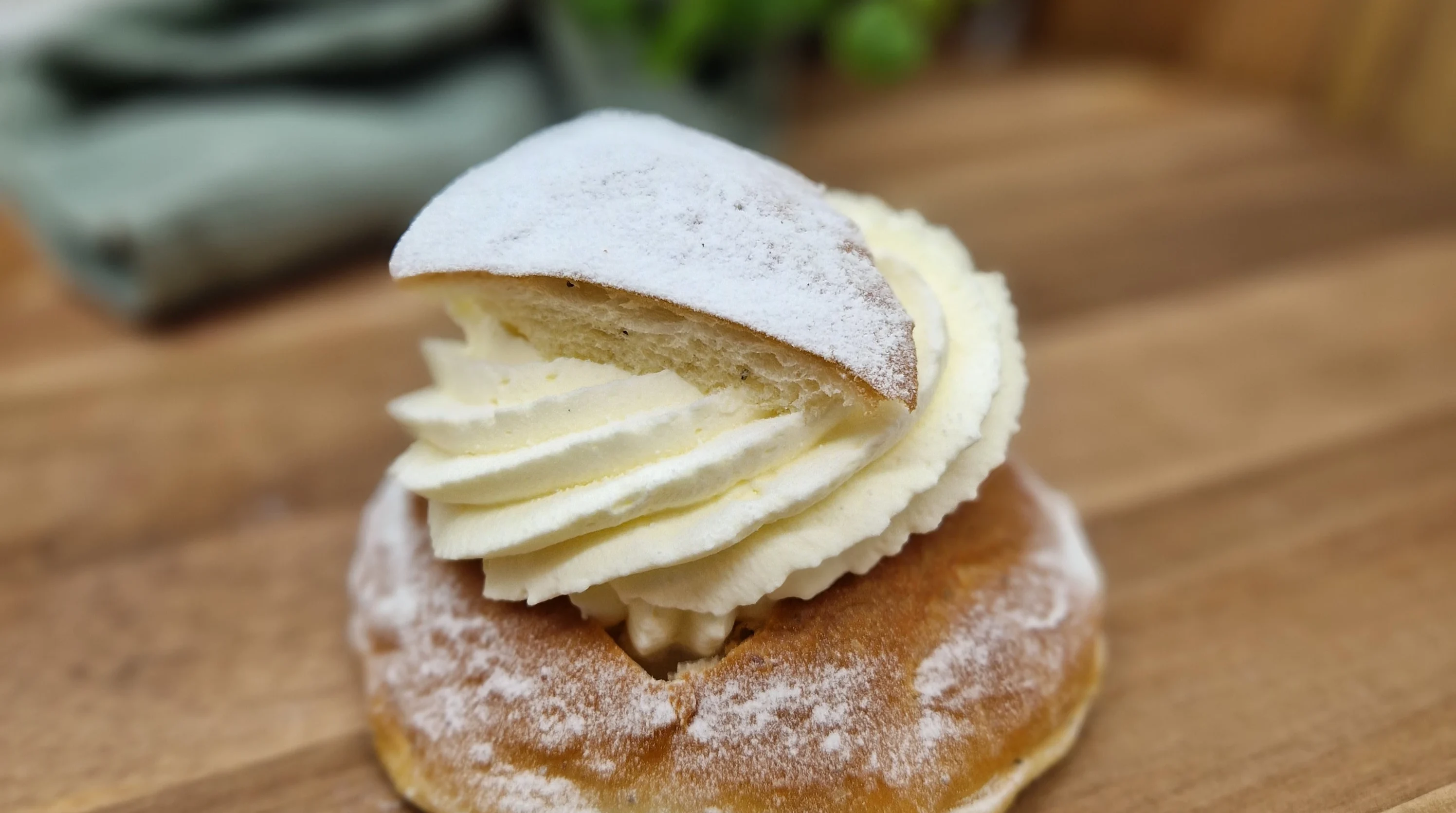 Semla med mandelfyllning, klippt lock dekorerad med florsocker.