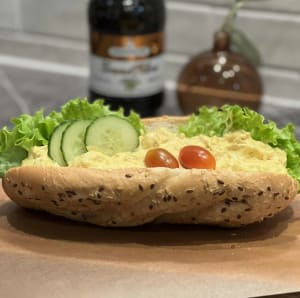 Baguette fylld med krämig kycklinröra toppad med färska grönsaker.