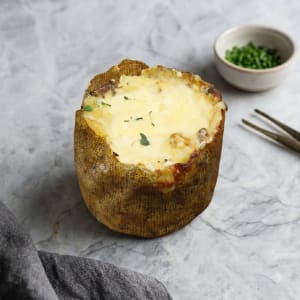 En gyllenbrun potatisbakelse fylld med krämig kantarellstuvning