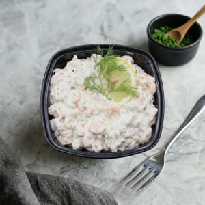 Klassisk krämig skagenröra med handskalade räkor och finhackad dill, serverad i en stilren skål med en dekorativ dillkvist på toppen.