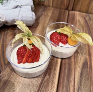Vaniljpanacotta toppad med färska jordgubbar på ett träfat