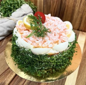 Rund räktårta med färsk dill runt om toppad med färska r'kor, ägg och citron