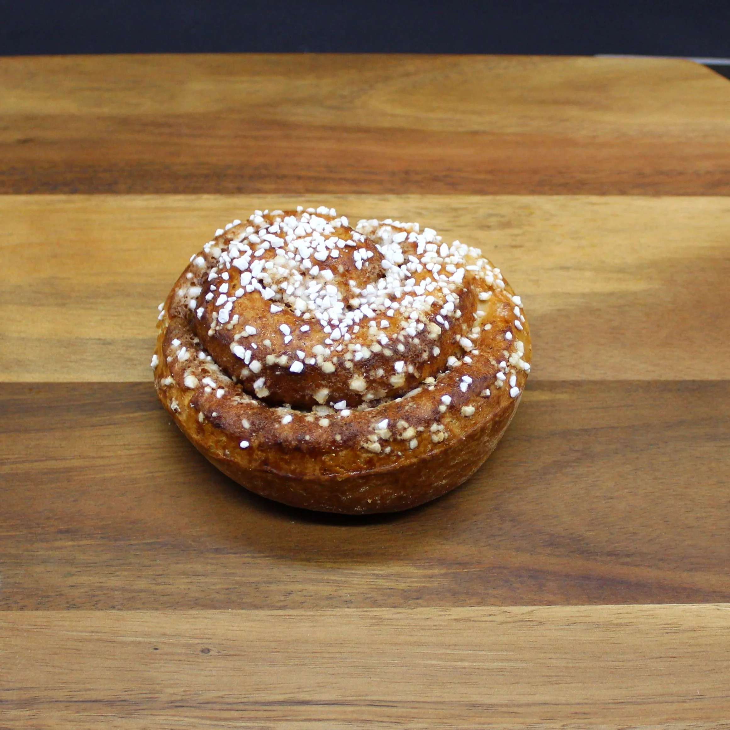 Kanelbulle toppad rikligt med pärlsocker