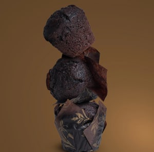 En stapel med tre chokladmuffins mot en brun bakgrund