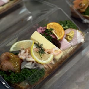 jullandgång, juliga tillbehör på bröd, En landgång med julskinka, rödbetssallad, Kvantumkökets köttbullar, lagrad cheddarost, ägg, räkor, löksill, gravad lax med hovmästarsås, garneras med färsk grönkål, clementin och citron.