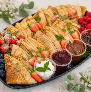 En pannkaksbuffe med olika toppings och frukt