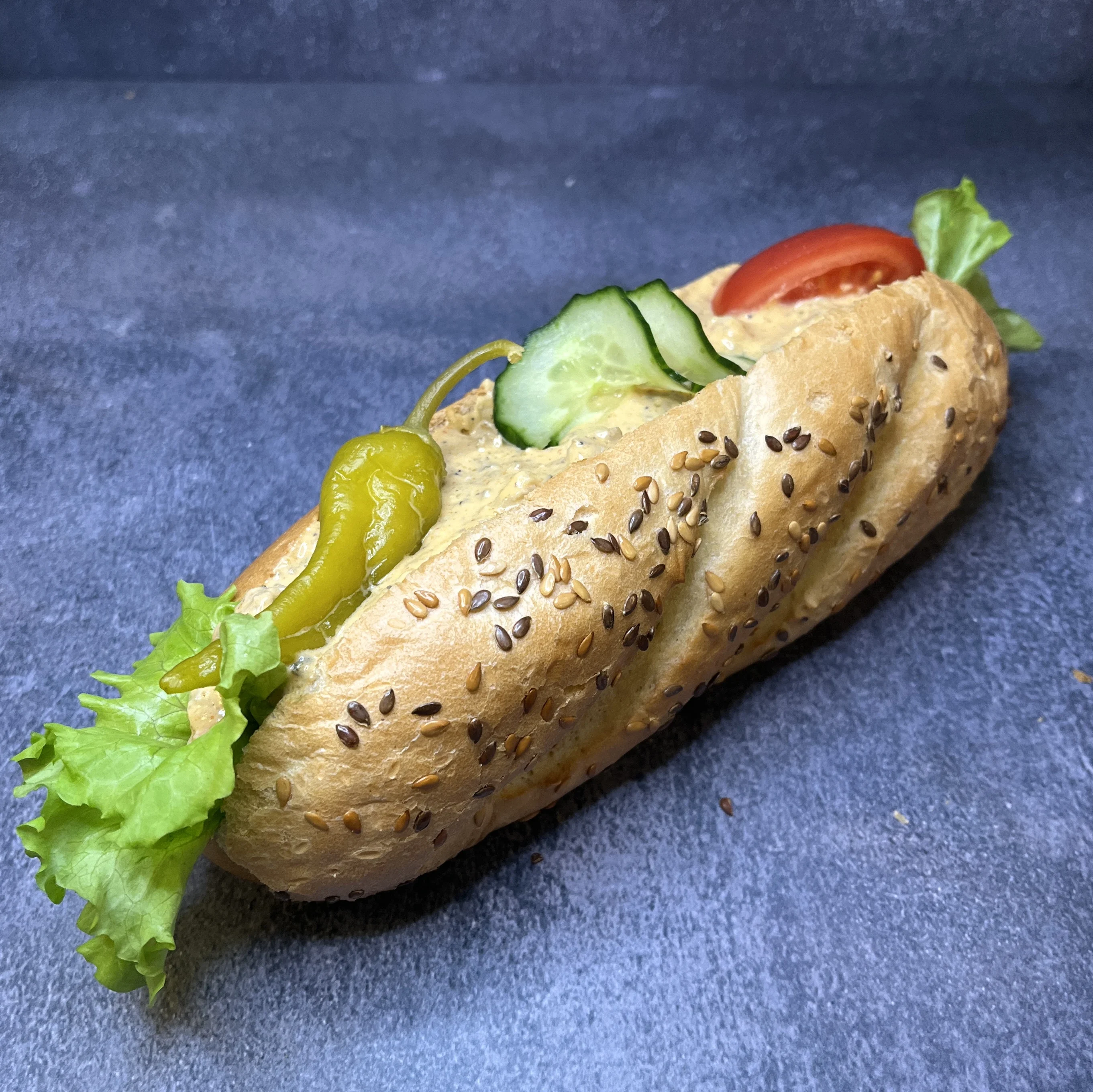 En baguette fylld med sallad, tomat, och kebabröra. Toppad med feferoni.