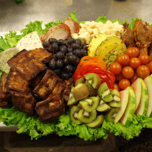 Vår grillplanka med exotiska frukter, honungsglaserade revben, grillade kycklingben och grillad fläskfilé. Ostkuber av vällagrad herrgårdsost och mögelost Bavaria Blu