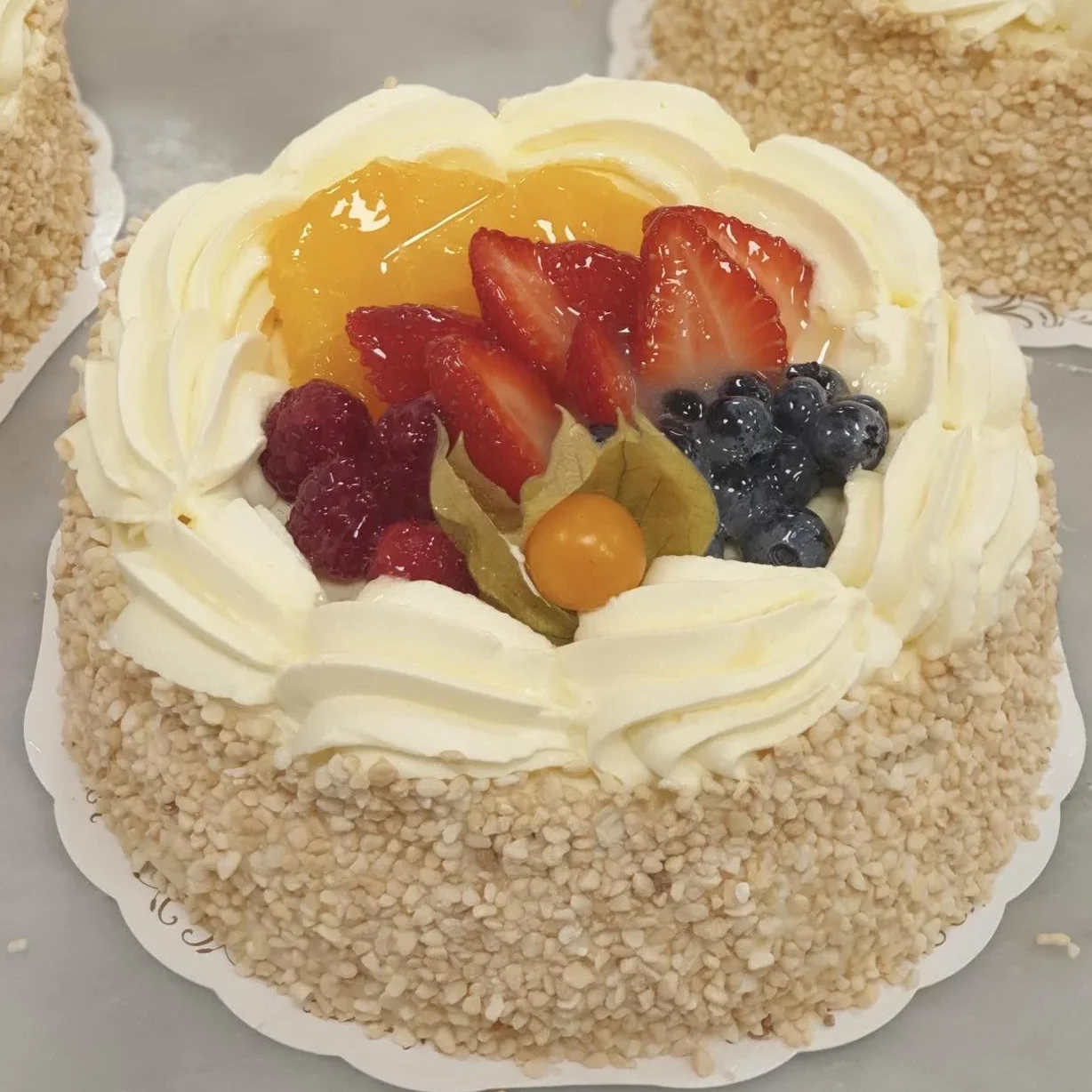 Tårta med grädde, frukt och bär toppad med gele