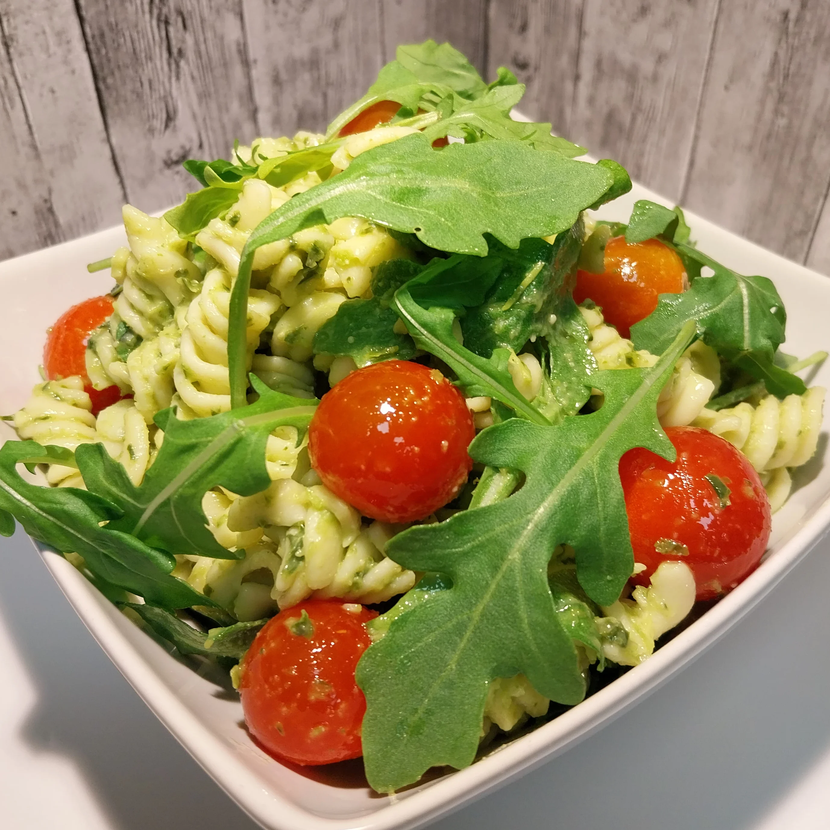 Pastasallad med pesto, körsbärstomater och ruccola.