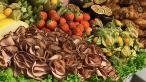 Bilden visar en exotisk planka med kött och frukt