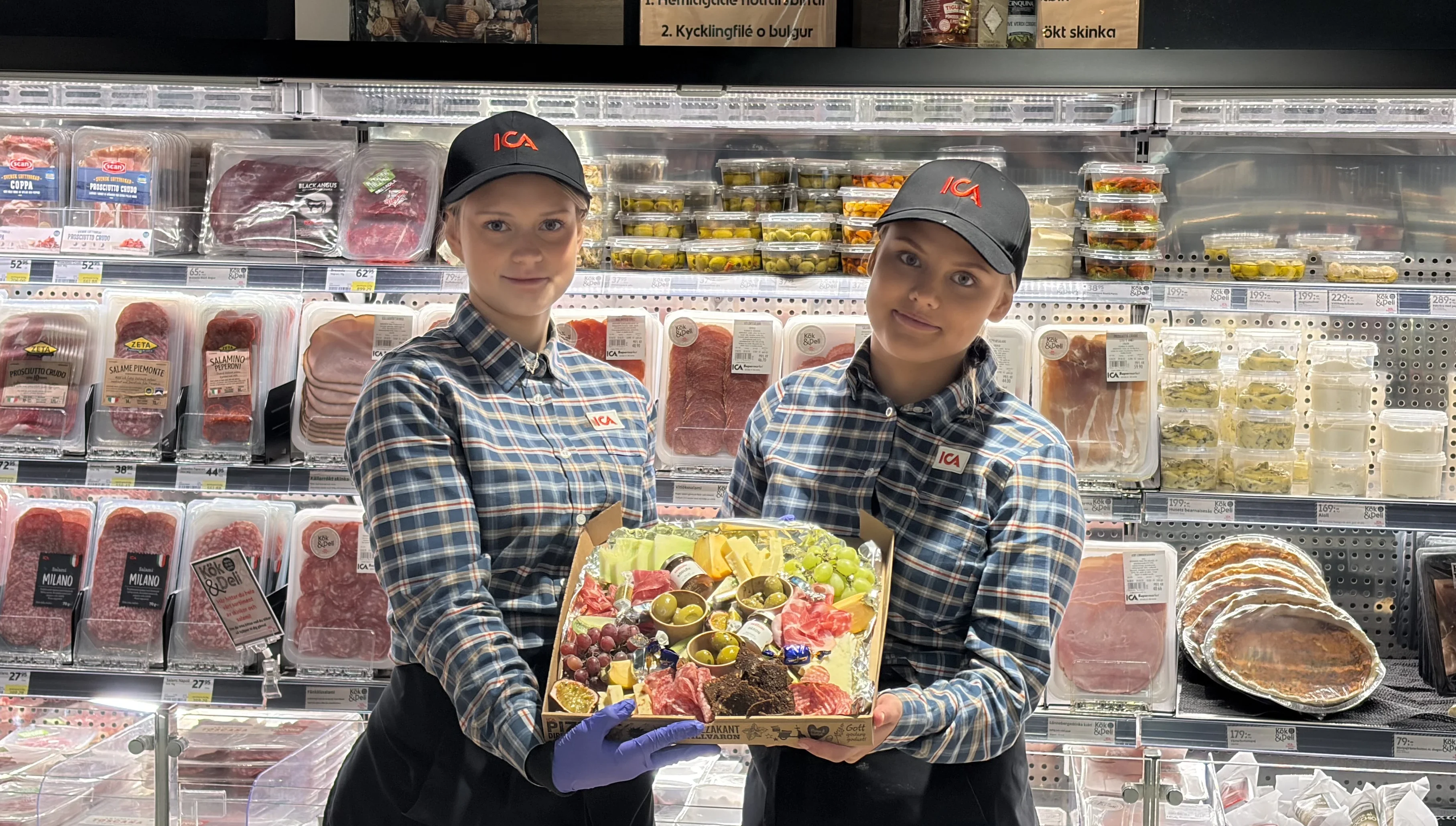 Plockbox som hålls i av två anställda framför delin