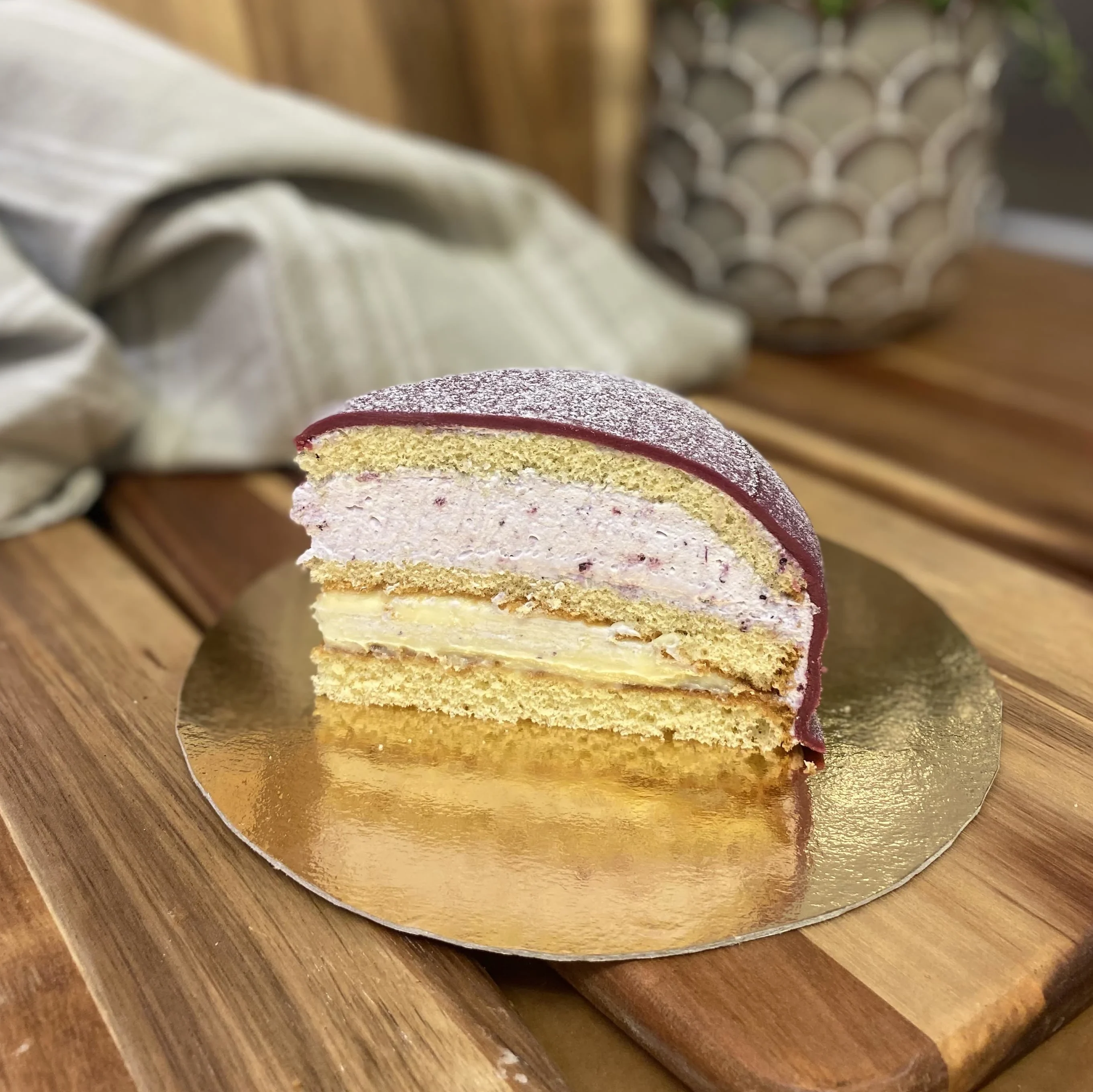 bit av en lila princesstårta med blåbässylt och vaniljkräm
