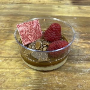 Dessert med kolamousse och en salt kolasås toppad med daim och hallon