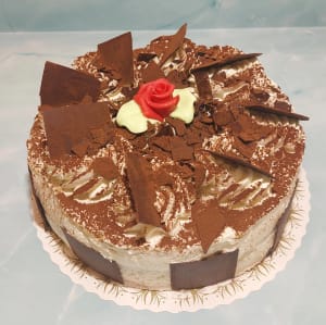 Hasselnötsmaräng med grädde, chokladrutor, toppad med kakao.