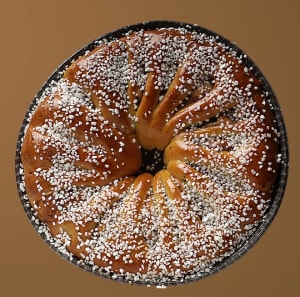 Kanelkrans med pärlsocker mot en brun bakgrund