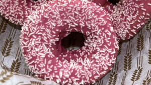 Donut med jordgubbsglasyr toppad med vit choklad strössel