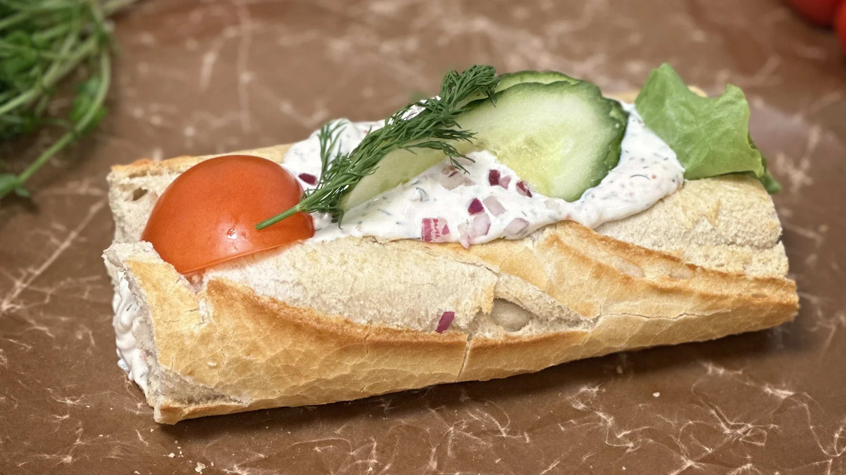 Skagenbaguette fylld med härlagad skagenröra och garnerad med gurka och tomat