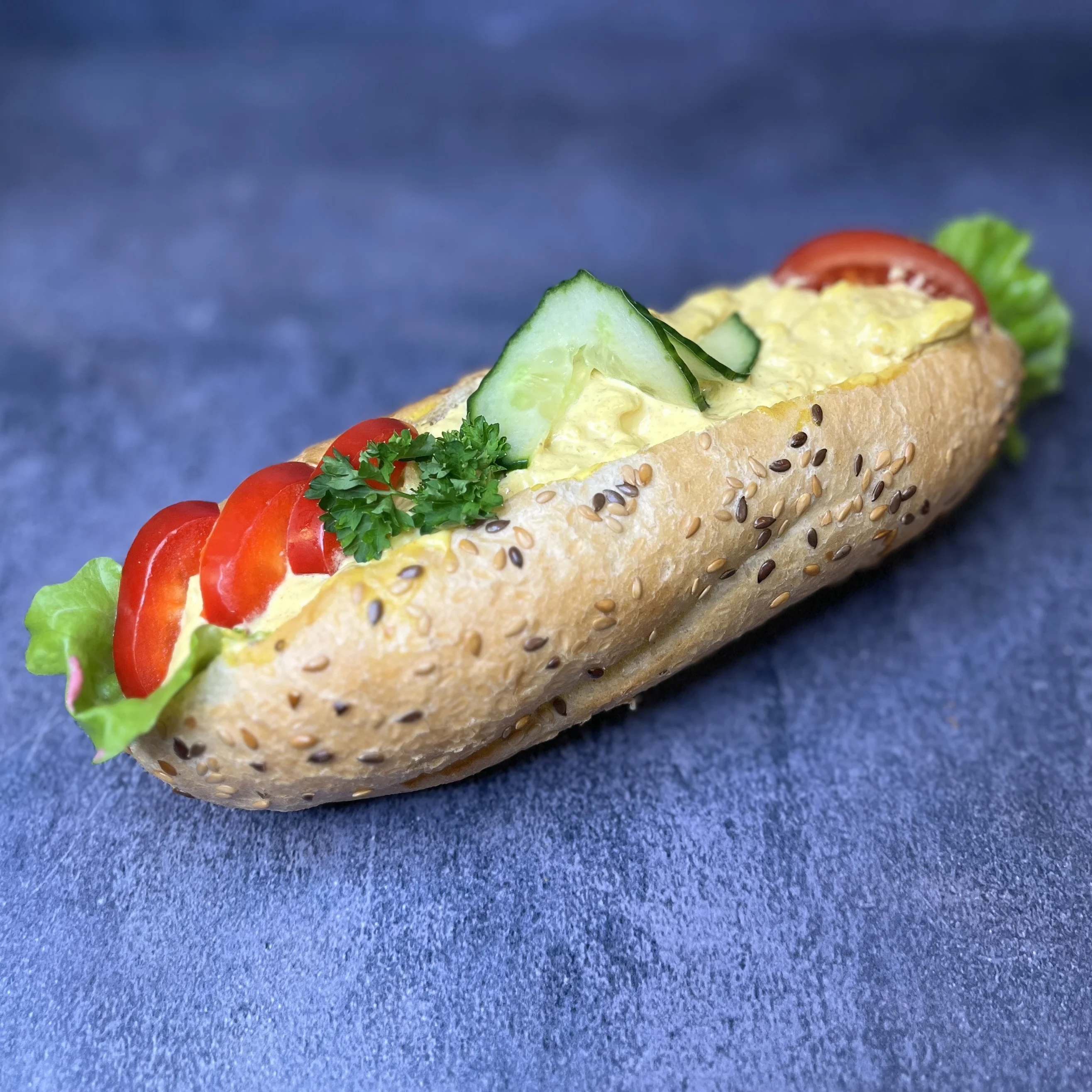 En baguette fylld med kycklingröra, sallad tomat och gurka.