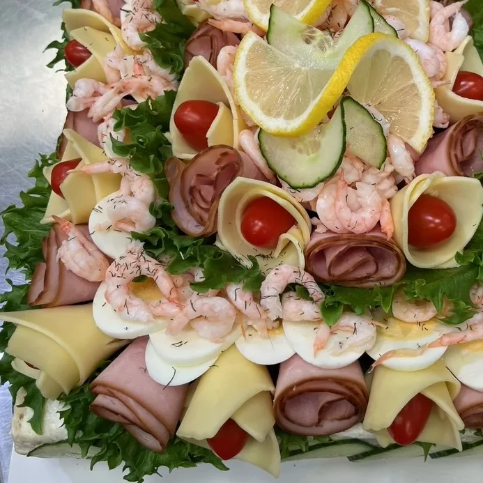 Vår poppuläraste smörgåstårta med äggröra, skinkröra och skagen, toppad med ost, skinka, ägg och räkor.