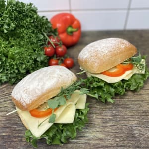 Två styck ljusa frallor fyllda med ost,skinka samt grönsaker