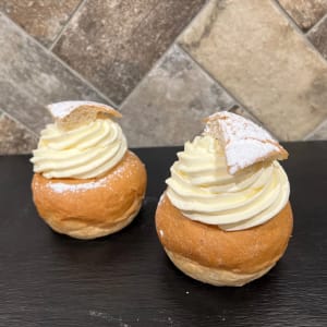 Semlor vi gjort på våra bullar som vi bakat rykande färska i vårat eget bageri. Med ljuvlig fyllning med vaniljkräm. Fluffig vispgrädde toppad kärlek och florsocker