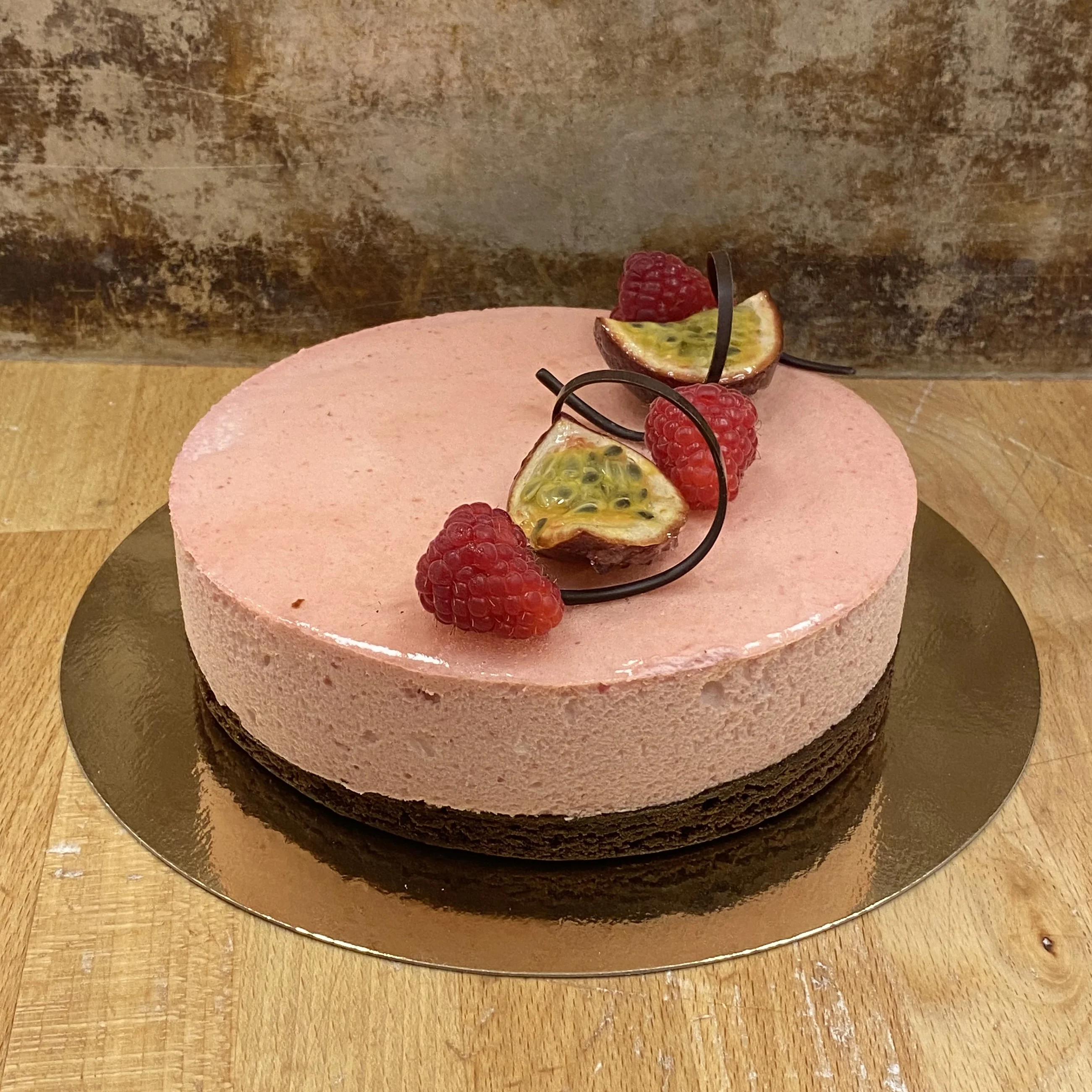 Browniebotten, passionfruktpannacotta, hallonmousse. Dekorerad med passionsfrukt, hallon och choklad.