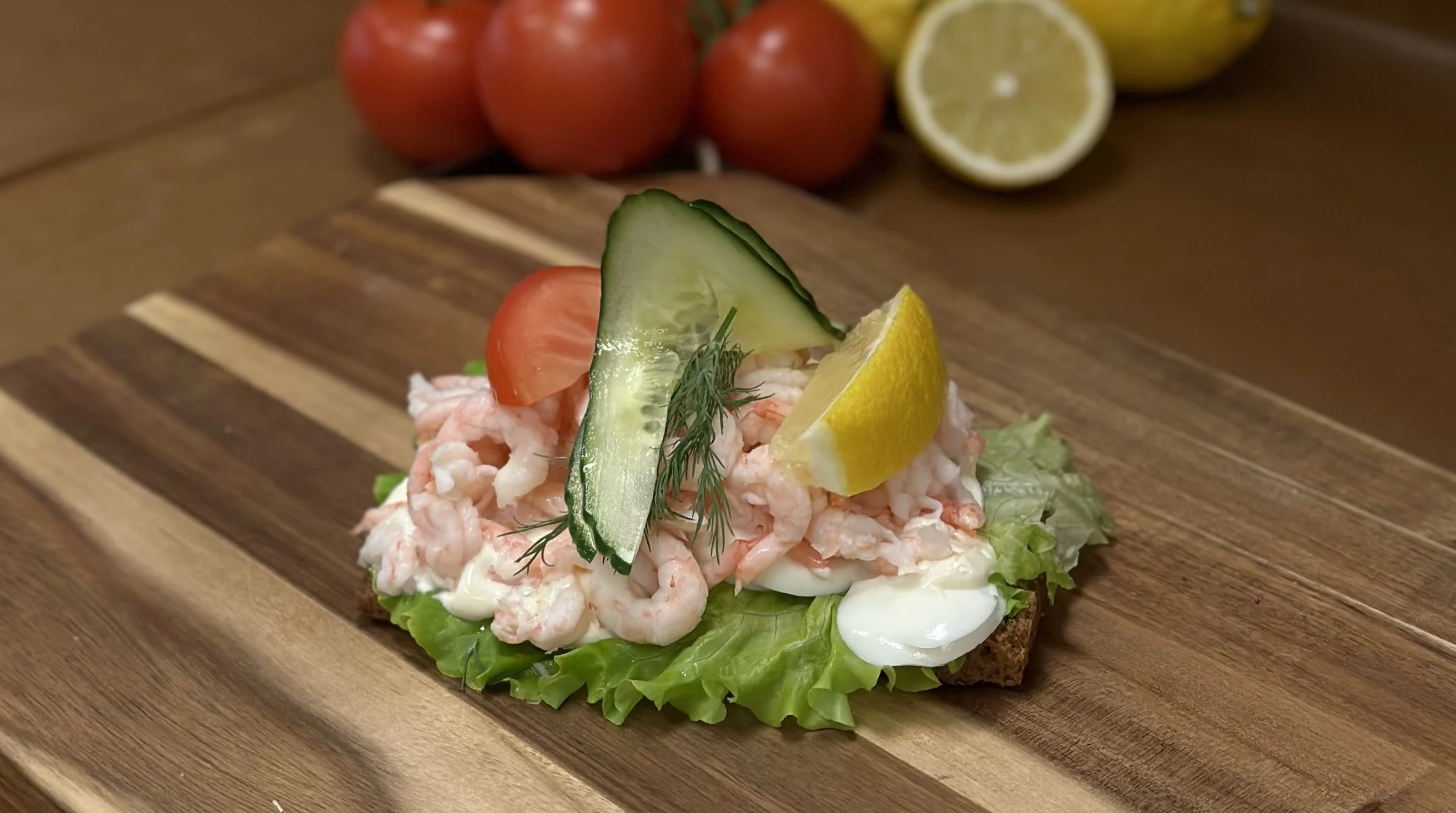 en räkmacka med handskalade räkor på mörkt bröd