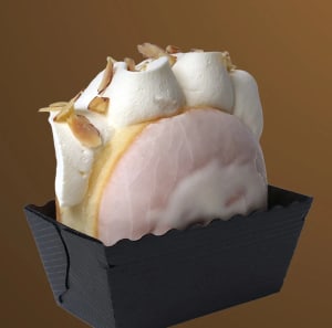 Mandel munk med grädde och rostad mandel står på högkant i en liten pappersform