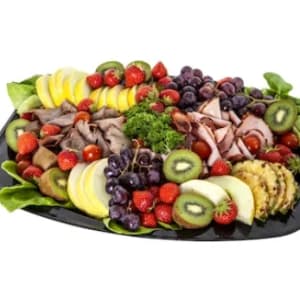 En planka med en massa olika frukter/bär och kött.