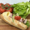 Nybakad baguette fylld med ost, skinka, sallad, tomat och gurka.
