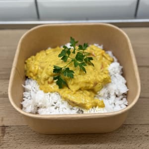 Kycklingcurry med basmatiris toppad med en persiljekvist.