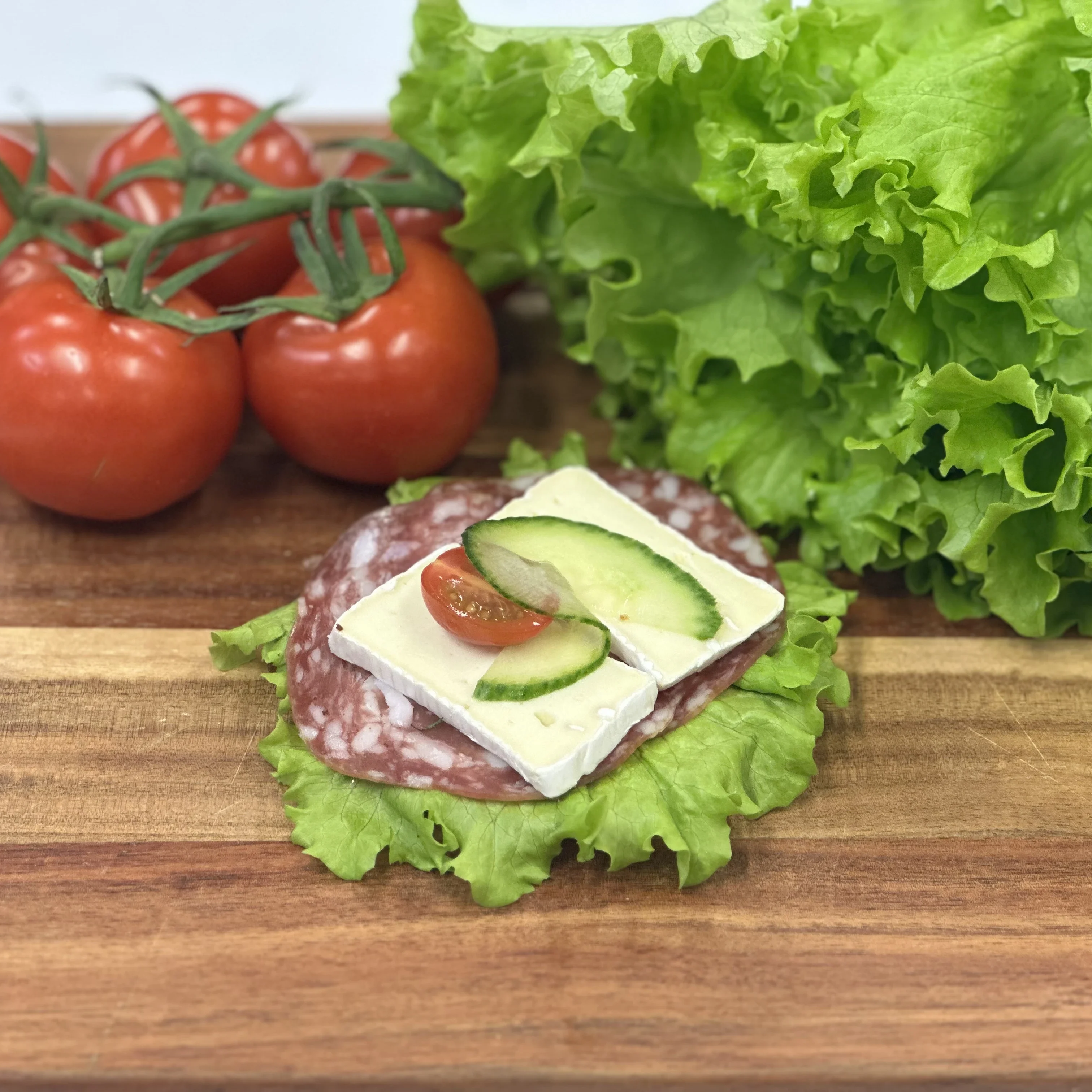 Smörrebröd med salami, brie, sallad, tomat och gurka.