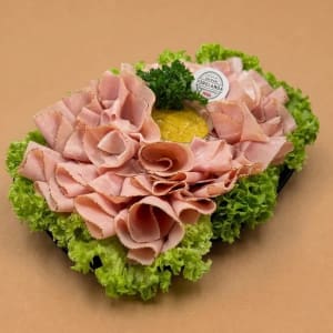 Ett fat med griljerad julskinka på en bädd av grönsallad.