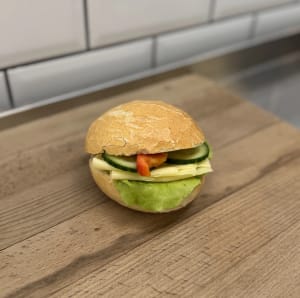 Ljus fralla med ost och grönsaker.