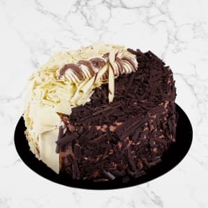 svart och vit chokladtårta. Täckt med hyvlad choklad och dekorerad med en chokladpinne.