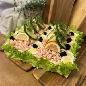 Smörgåstårta toppad med räkor och ägg.
