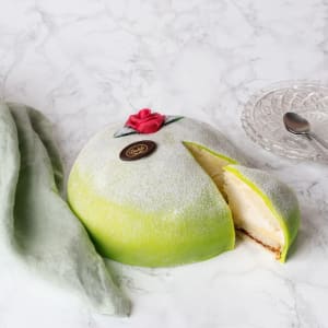 Grön Princesstårta med ros på toppen.