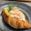 Nygräddad smörcroissant fylld med skagenröra, toppad med handskalade räkor, citron och dill.